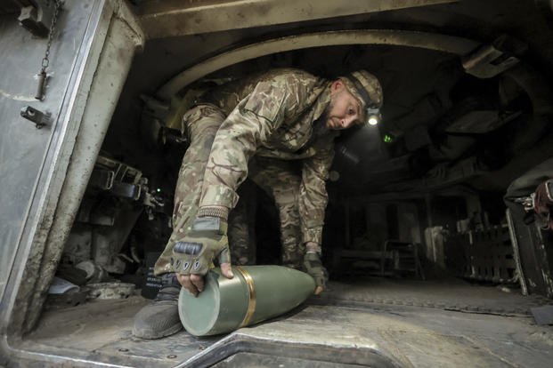 Ukrainian soldier prepares to fire a howitzer toward Russian army positions