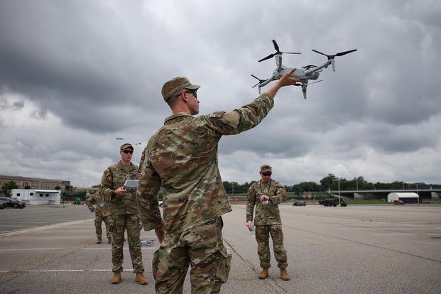 A soldier holds a drone in the Pentagon parking lot