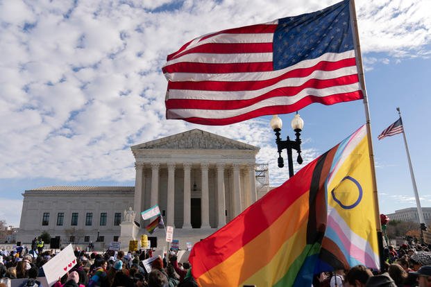 Transgender rights supporters rally outside of the Supreme Court