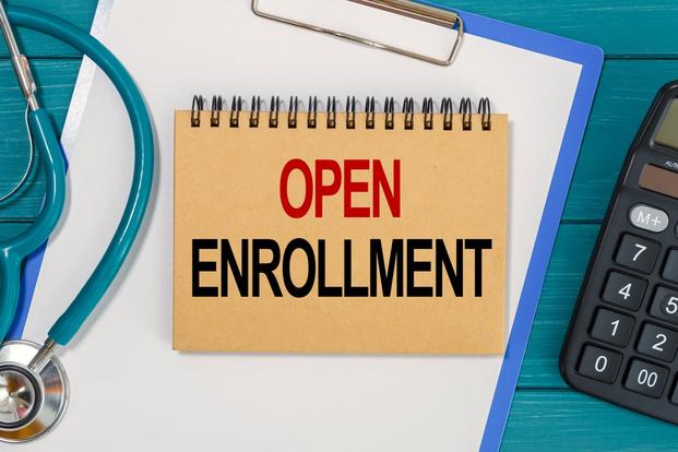 A notebook with the words open enrollment on the cover.
