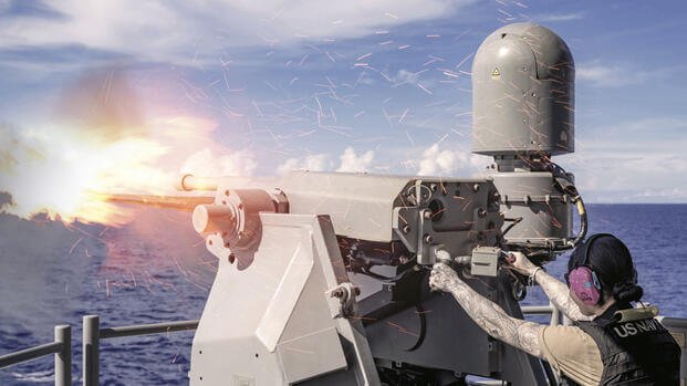 Navy Seaman Elizabeth Furlan fires a Mark 38 crew-served weapon system