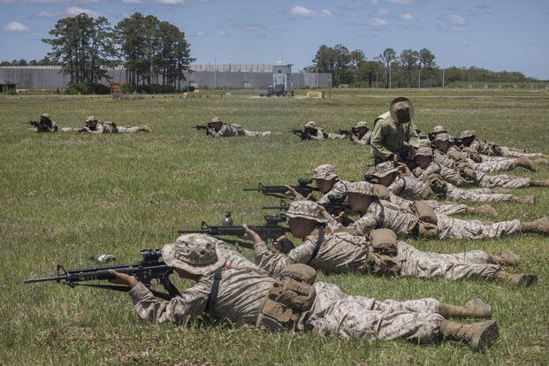 A U.S. Marine Corps drill instructor teaches one recruit how to sight his weapon during a dry-fire rifle training exercise, Wednesday, May 11, 2022, in Parris Island, SC. (AP Photo/Stephen B. Morton)