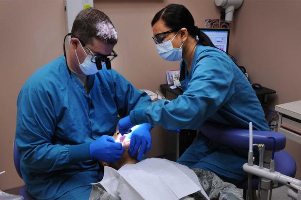 A dentist, and a Red Cross dental assistant trainee examine a patient at the Mike O'Callaghan Federal Hospital Dental Clinic, Nellis Air Force Base. (U.S. Air Force photo by Airman 1st Class Matthew Lancaster) 