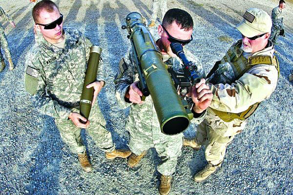 A civilian instructor coaches two paratroopers with the 82nd Airborne Division's 1st Brigade Combat Team on how to use a Carl Gustav 84mm recoilless rifle during a certification class Dec. 6, 2011, at Fort Bragg, North Carolina. (U.S. Army photo)