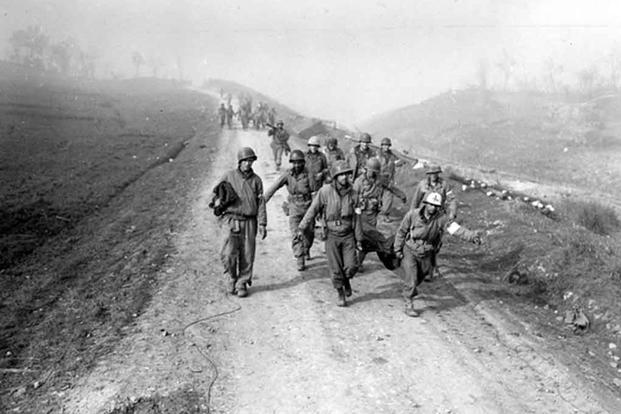 Litter bearers bring back wounded during attempt to span the Rapido River near Cassino, Italy, January 23, 1944.