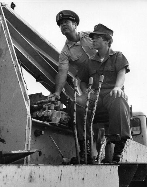  Constructionman Camella J. Jones learns how to operate a large crane from a Chief Petty Officer. (Photo: U.S. Navy/PH3 Paul Mansfield) 