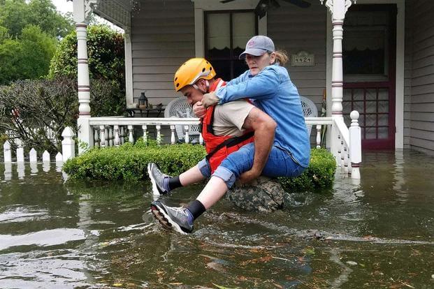 A Texas National Guardsman carries a resident from her flooded home following Hurricane Harvey in Houston, Aug. 27, 2017. (National Guard/Lt. Zachary West )