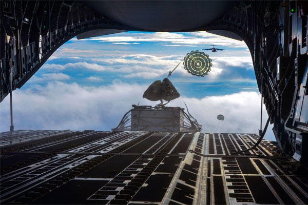 Two heavy container delivery systems plunge from the back of a C-17 Globemaster III aircraft to forces on the ground during the simulated Rainier War Dec. 6, 2014. (U.S. Air Force photo/Staff Sgt. Russ Jackson)
