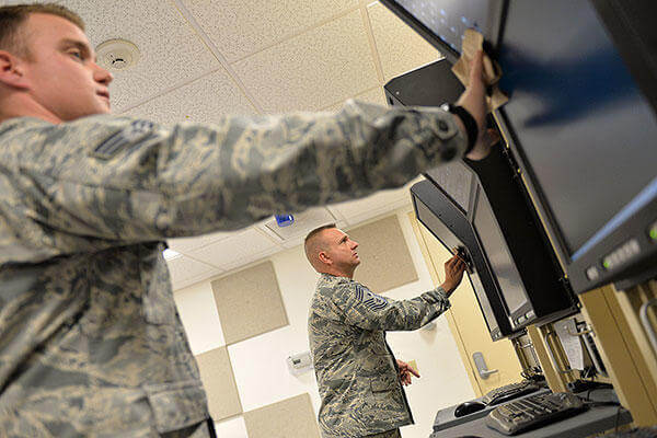 Chief Master Sgt. Michael Ditore, the 432nd Wing/432nd Air Expeditionary Wing command chief, right, cleans monitors with Senior Airman Robert as part of a preventative maintenance inspection. (U.S. Air Force photo/Senior Airman Christian Clausen)