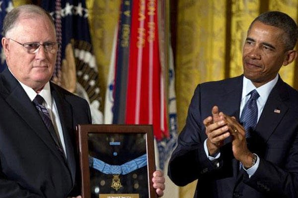 President Barack Obama applauds at right after presenting the Medal of Honor for Army Spc. Donald P. Sloat to his brother William Sloat, left, in the East Room of the White House in Washington, Monday, Sept., 15, 2014 (AP Photo/Carolyn Kaster)
