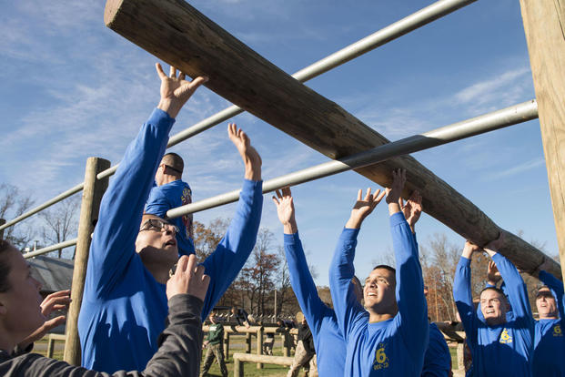 Candidates in Officer Candidate School lift a log through an obstacle during an exercise at Marine Corps Base Quantico, Virginia,. Nov. 20, 2015. (Photo by Lance Cpl. Erasmo Cortez III)