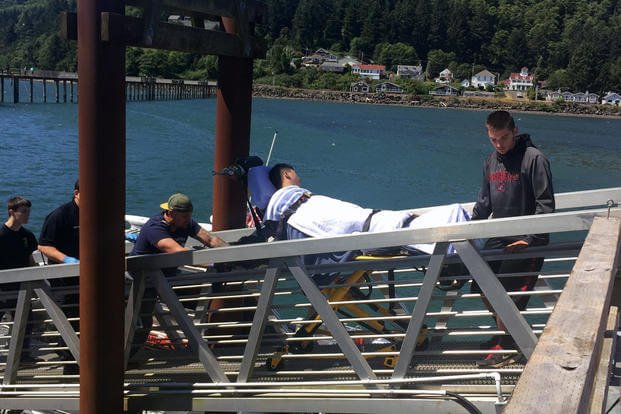 Coast Guard crewmembers transfer a 29-year-old male to emergency medical services at Station Tillamook Bay after pulling him from the water near Girabaldi, Ore., July 10, 2016. (Photo: U.S. Coast Guard)