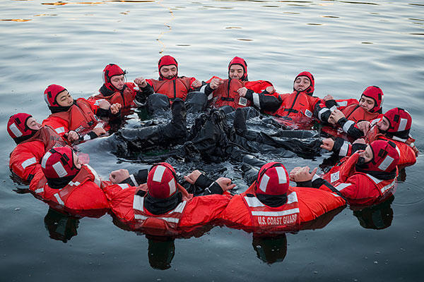 Crew members from the Coast Guard Cutter Spencer leak-test their survival suits in chilly Boston Harbor Nov. 18, 2015. As air and water temperatures drop, the Spencer crew are preparing for the approaching winter. (U.S. Coast Guard/PO3 Ross Ruddell)