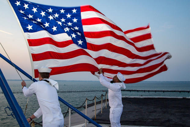 Sailors assigned to the color guard aboard the aircraft carrier USS Dwight D. Eisenhower (CVN 69) retire the colors (U.S. Navy/Mass Communication Specialist 2nd Class Andrew J. Sneeringer.)