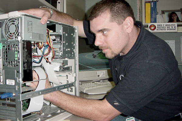 Marine performing computer maintenance.