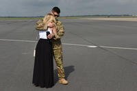 A deploying North Carolina Air National Guardsman hugs his wife and says goodbye before departure at the North Carolina Air National Guard Base, Charlotte Douglas International Airport. (Nathan Clark/U.S. Air Guard)