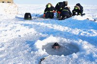 Chief Hospital Corpsman Kristopher Mandaro, assigned to Underwater Construction Team One (UCT 1), surfaces from a waterhole during a torpedo exercise in the Arctic Circle in support of Ice Exercise (ICEX) 2018, March 16. (U.S. Navy photo/Daniel Hinton)