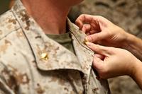 A Marine major is pinned with his new rank during a promotion ceremony in 2014. More officers could join the sea services at higher ranks as leaders look to attract those in technical fields, such as cyber. (Cpl. Emmanuel Ramos/Marine Corps)