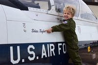 Tobias Taylor, Pilot for a Day, points to his name on a T-6 Texan II on the flight line, Dec. 6, 2018, at Columbus Air Force Base, Mississippi. (U.S. Air Force/Elizabeth Owens)