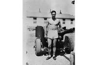 Bob Dole stands in front of artillery in a 1943 photo. (Dole Archive)