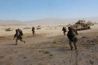 Infantrymen from the 3rd Infantry Division’s 2nd Armored Brigade Combat Team sprint for cover during a May 8 attack on the fictional town of Razish at the National Training Center at Fort Irwin, California. (Matthew Cox/Staff)