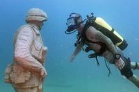 Shawn Campbell, a former staff sergeant and now a master diver, admires the detail of one of the statues at the Circle of Heroes underwater veterans memorial off the coast of Clearwater, Fla. (U.S. Army/Video still by Bill Mills)