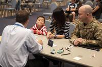 A U.S. Embassy employee shares a moment with a boy and his family applying for a passport at a United States Embassy Outreach event at Yokota Air Base, Japan, on May 22, 2019. (U.S. Air Force photo by Senior Airman Matthew Gilmore)