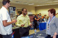 A man speaks to a recruiter at a job fair.