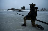 A Special Tactics operator guards an F-22 Raptor