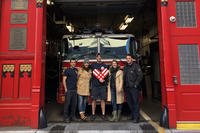 military spouses and firefighters in front of fire truck