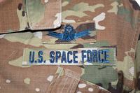 Airmen who transfer into the U.S. Space Force will continue to wear the OCP utility uniform, but with blue thread and a colored U.S. flag.