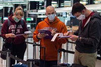 three perople in masks at an airport