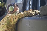 A soldier conducts routine maintenance on an AH-64 Apache helicopter.