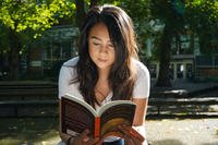 woman reading book outside