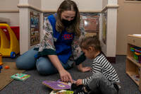 childcare worker and child playing on the floor