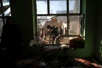An Afghan journalist films a damaged house after a mortar shell attack in Kabul, Afghanistan.