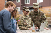 Military members look at laptop