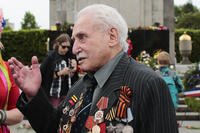 Soviet war veteran David Dushman, 92, center, speaks to people holding Ukrainian flags
