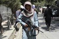 A Taliban fighter stands guard at a checkpoint in the Wazir Akbar Khan neighborhood,