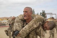 A Marine recruit carries another recruit during training.