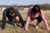 Two runners stretch before a 5K run in Belton, Texas.