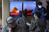 People watch a TV showing an image of North Korea's missile launch.