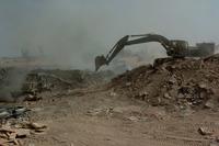 Soldiers use a bulldozer and excavator to maneuver trash at a burn pit in Balad, Iraq, Sept.24, 2004. (U.S. Army photo) A burn pit at a landfill in Balad, Iraq.