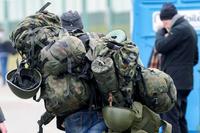 A man carries military combat gear as he leaves Poland to fight in Ukraine.