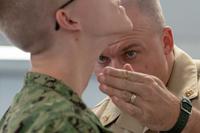 Navy commander checks recruit's shave.