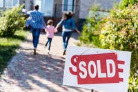 Family Running to New Home with Sold Sign