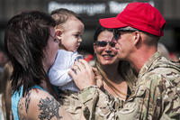 A senior airman embraces his wife and son after returning from deployment.