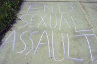&quot;End Sexual Assault&quot; is written on a sidewalk.