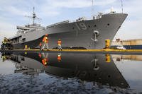 Port workers prepare the docking of the USS Blue Ridge, the flagship of the US Navy Seventh Fleet, at Manila South Harbor