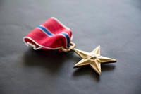 The Bronze Star is authorized by Executive Order No. 9419 on Feb. 4, 1944, and is awarded to a person in any branch of military service who, while serving in any capacity with the armed forces of the United States on or after Dec. 7, 1941, shall have distinguished him or herself by heroic or meritorious achievement or service, not involving participation in aerial flight, in connection with military operations against an armed enemy.